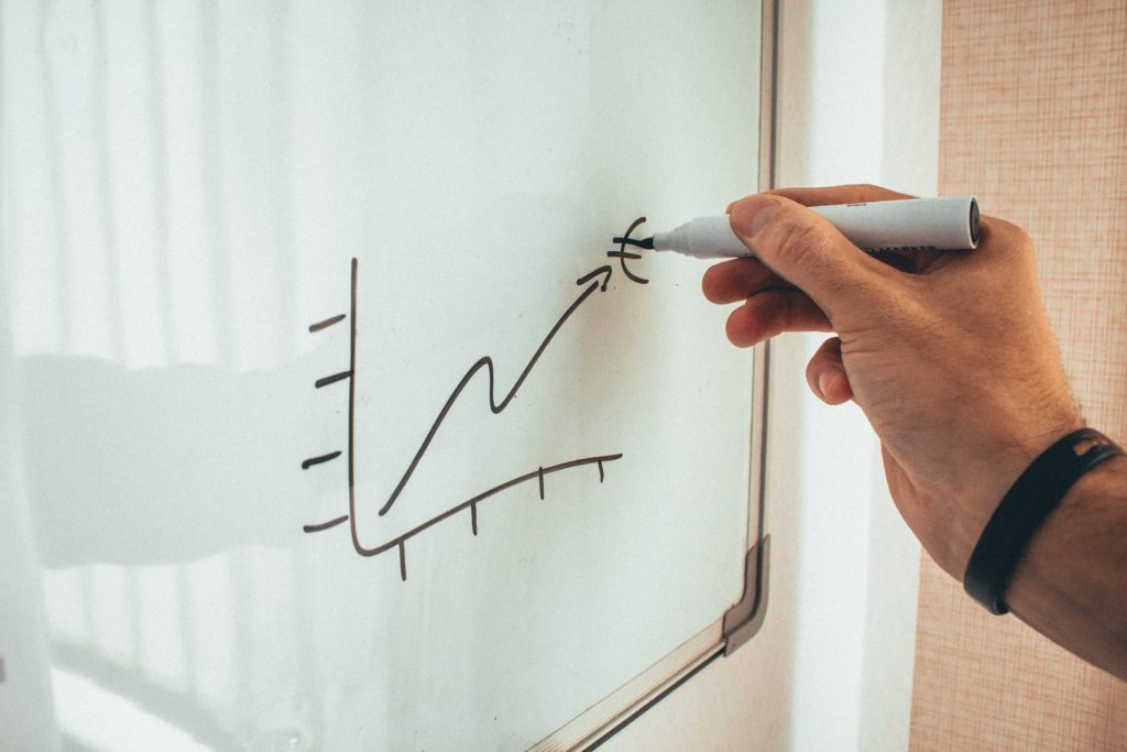 Man drawing on whiteboard to illustrate benefits of remarketing and retargeting